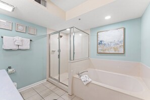 Un baño con ducha de vidrio, bañera y retrete.