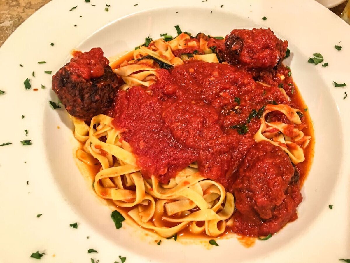 A plate of pasta with meatballs and tomato sauce.