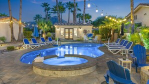 A swimming pool with lounge chairs, a hot tub, and string lights. - California Paradise: #231868 3BR Pool, Spa, BBQ! (La Quinta)