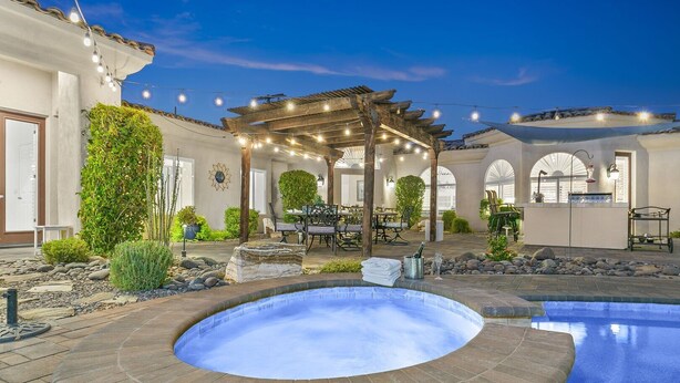 A hot tub in a backyard with a pergola, outdoor dining area, and a pool. - California Paradise: #231868 3BR Pool, Spa, BBQ! (La Quinta)