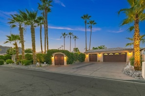 A residential property with a gated entrance, a garage, and a driveway.