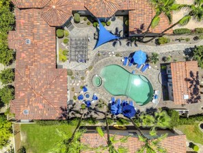 An aerial view of a resort with a swimming pool, sun loungers, and a covered seating area. - California Paradise: #231868 3BR Pool, Spa, BBQ! (La Quinta)