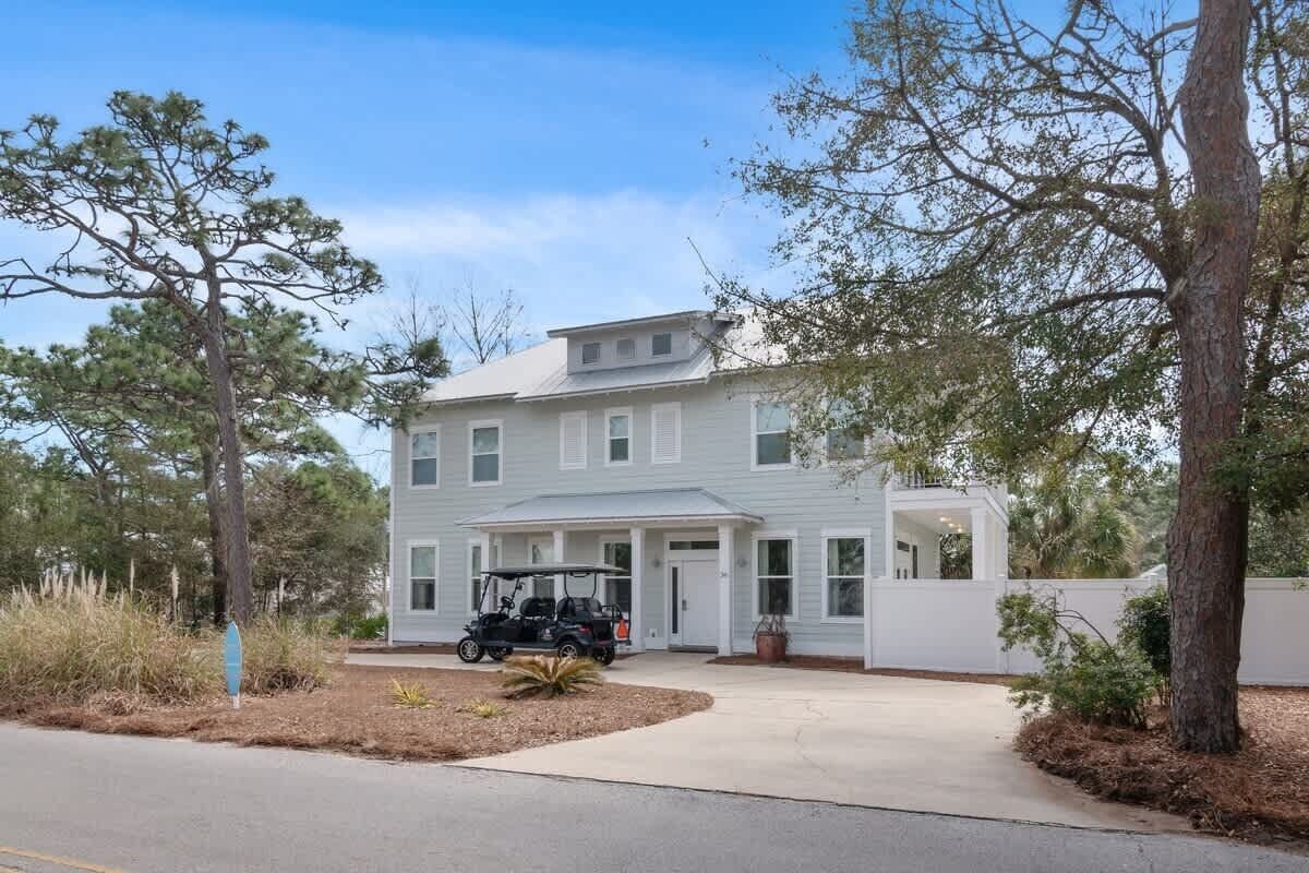 A two-story house with a garage, a driveway, and a golf cart parked in front.