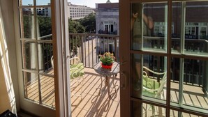 A balcony with a table, chairs, and potted plants. - Step into a spacious, luxury condo that has it all – a premiere location in the heart of the Historic District and floor-to-ceiling window views of the Savannah River, Talmadge Bridge and City Hall. 5th floor.Best river views in the building. (Savannah)