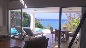 A room with a view of the sea, a pool, and outdoor seating. - BOUGAINVILLIERS Very Private and Charming Villa With Sea View Close to the Beach (Anse de Marigot)
