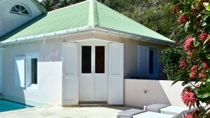 A small building with a green roof, a pool, and outdoor seating. - BOUGAINVILLIERS Very Private and Charming Villa With Sea View Close to the Beach (Anse de Marigot)