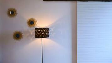 Un mur orné de trois appliques murales en forme de soleil et d’un luminaire moderne aux motifs géométriques.