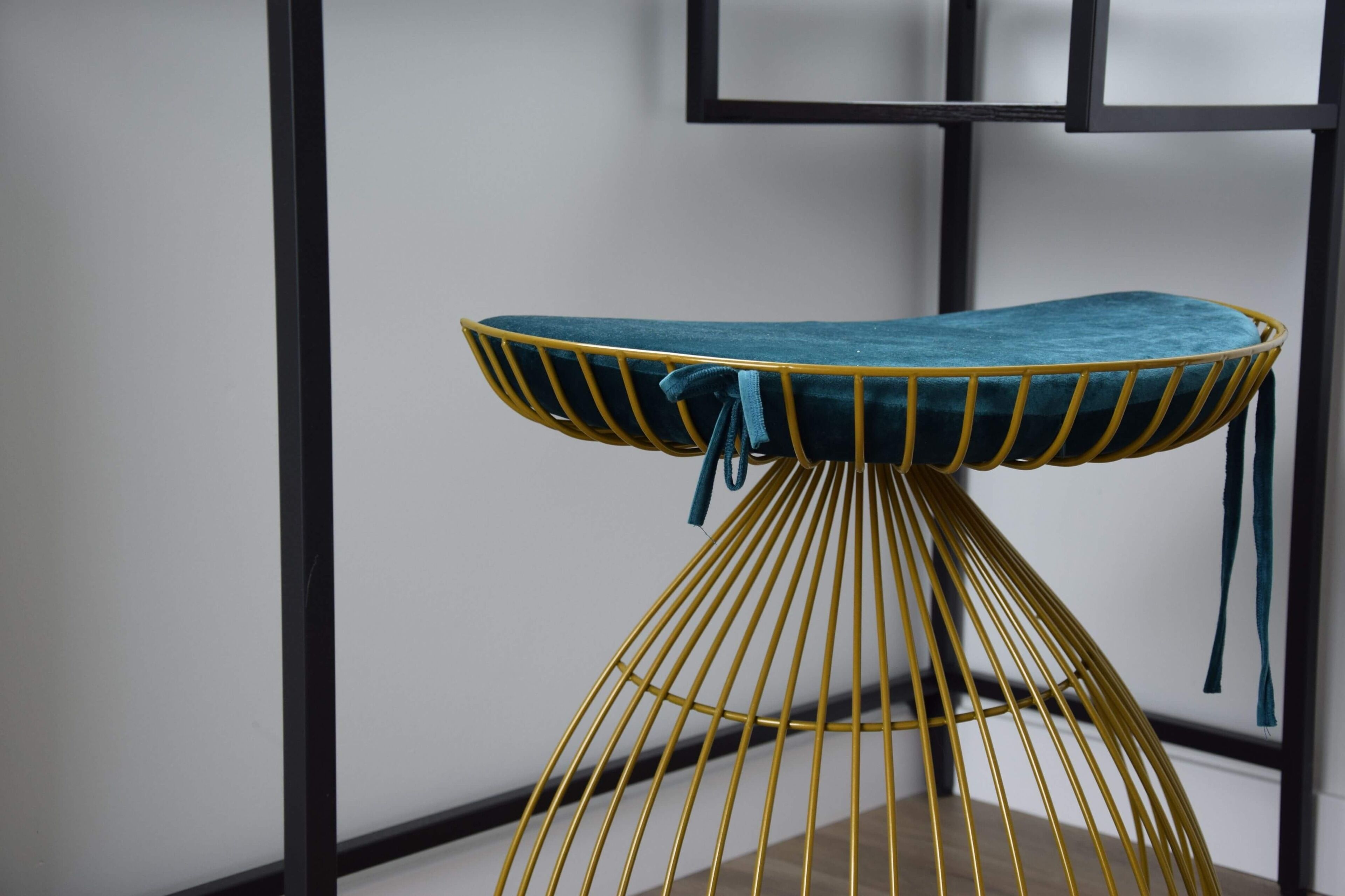 Uma mesa moderna, em estrutura de fio amarelo, com almofada verde-água.