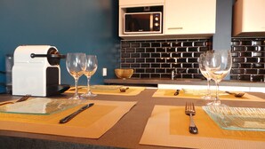 Eine Küche mit Mikrowelle, Toaster und zwei Weingläsern auf einem Tisch mit Tischsets und Besteck.