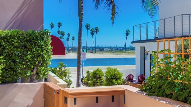 Ein modernes Gebäude mit einem Balkon, der auf einen Strand und den Ozean blickt.