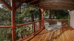 A wooden deck with a glass table and chairs, surrounded by trees. - Just blocks from UC, Simons, MSRI, Haas and Goldman Schools with great Bay views (Berkeley)