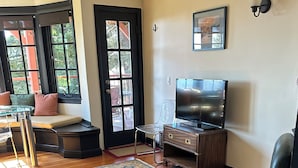 A living room with a TV, a sofa, a coffee table, and a patterned rug. - Just blocks from UC, Simons, MSRI, Haas and Goldman Schools with great Bay views (Berkeley)