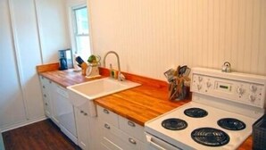 Une cuisine avec un four blanc, un évier et des plans de travail en bois.