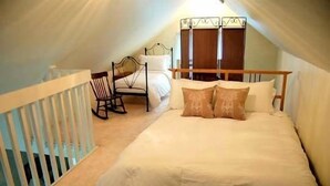 Une chambre avec un lit simple, une chaise et une armoire.