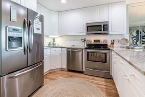 Enjoy cooking in this well-equipped kitchen with a refrigerator, dishwasher, oven, and microwave.