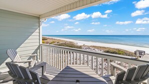 A covered deck with Adirondack chairs overlooking a beach. - Beautifully Decorated Gulf Front Townhome In Private Gated Community (Santa Rosa Beach)