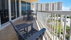 A balcony with a table and chairs, overlooking a residential area with high-rise buildings. - Fully equipped open-concept condo w/private balcony in Destin! 🌺 (Destiin)