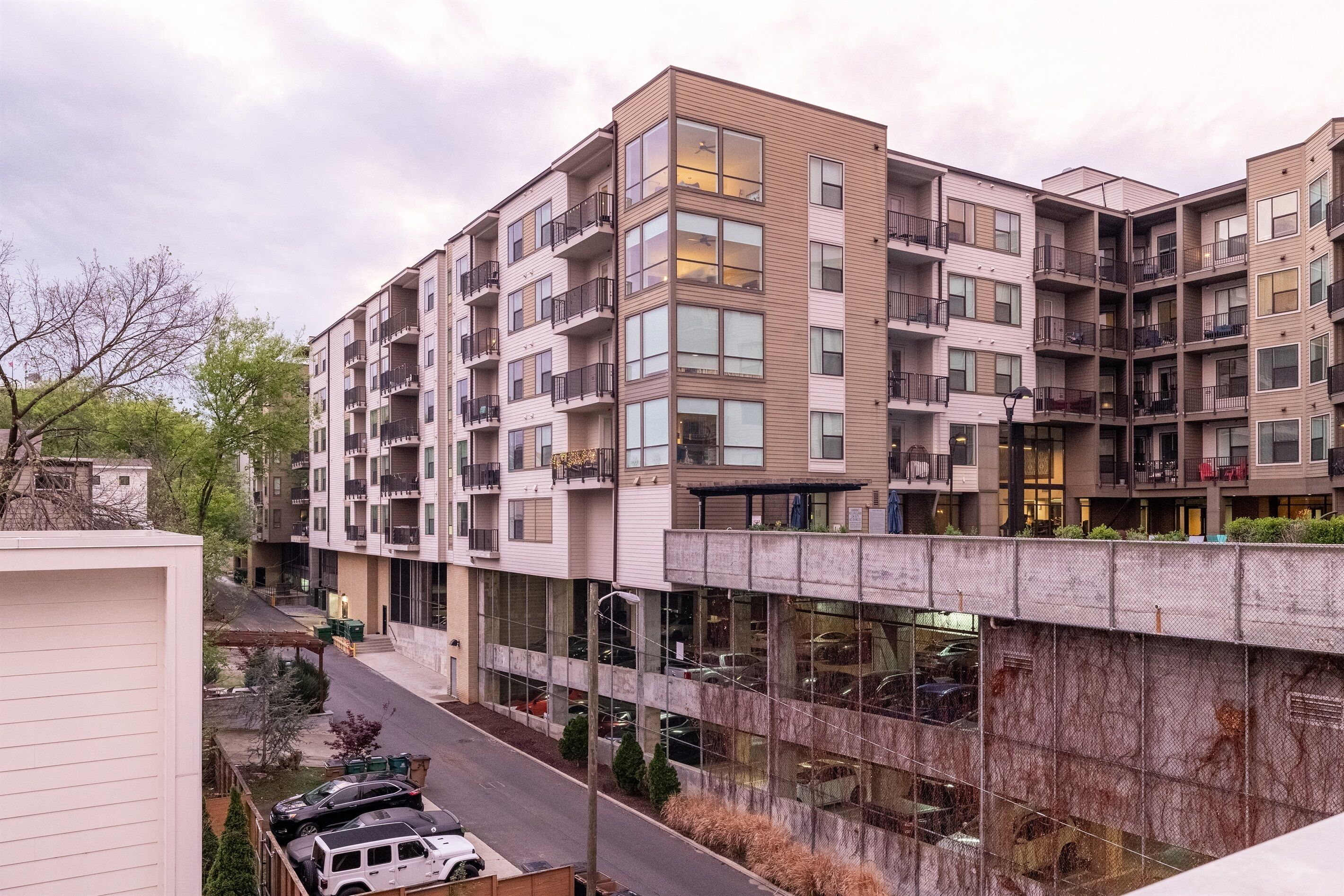 Un immeuble résidentiel à plusieurs étages, doté de balcons, de grandes fenêtres et d’une galerie couverte.