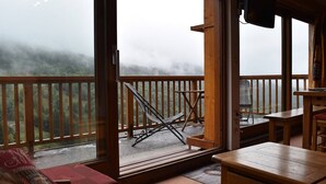 A cozy room with a large window overlooking a forested area. - Cozy 2-Room Mezzanine Apartment for 6 in Méribel Center, 200m from Slopes (Méribel)