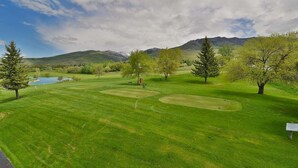 A golf course with well-maintained grass, trees, and a pond. - Private deck, BBQ Grill, view of golf course (Eden)