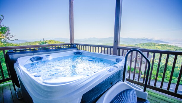 A hot tub on a wooden deck with a view of mountains. - Walk to ski slopes! INCREDIBLE MTN VIEWS,SUNSETS, HOTTUB, FIREPLACE (Sugar Mountain)