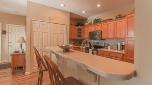 A kitchen with wooden cabinets, a microwave, and a coffee maker. - Walk to ski slopes! INCREDIBLE MTN VIEWS,SUNSETS, HOTTUB, FIREPLACE (Sugar Mountain)