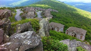 A residential area with houses on a hillside, surrounded by greenery and mountains. - Walk to ski slopes! INCREDIBLE MTN VIEWS,SUNSETS, HOTTUB, FIREPLACE (Sugar Mountain)