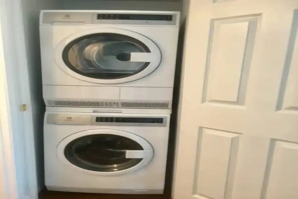 A compact laundry room with two stacked washing machines.