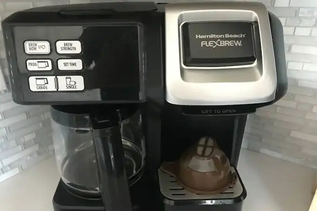 Una macchina per caffè Hamilton Beach Flexbrew con caraffa trasparente e compatibile con cialde monoporzione.