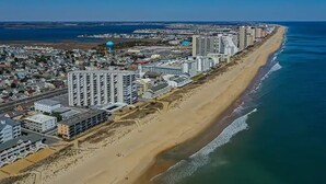 A coastal cityscape with high-rise buildings along the beach, a clear sky, and a calm sea. - Direct Oceanfront Renovated Condo | Sunrise | Sleeps 8 (Ocean City)