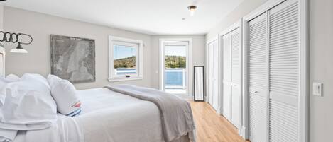 A bedroom with a bed, a map on the wall, and a view of the outdoors.