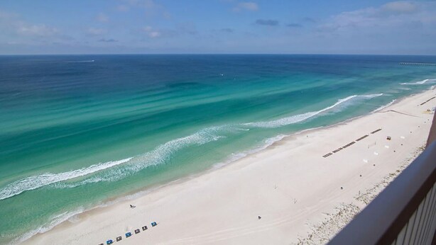A beach with clear turquoise waters and a sandy shore.