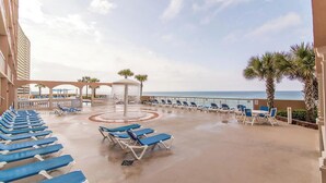 A pool area with blue lounge chairs and a central fountain.