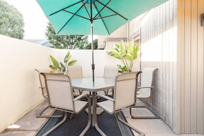 Enjoy casual dining or meetings in this outdoor space with a round table and comfortable seating.