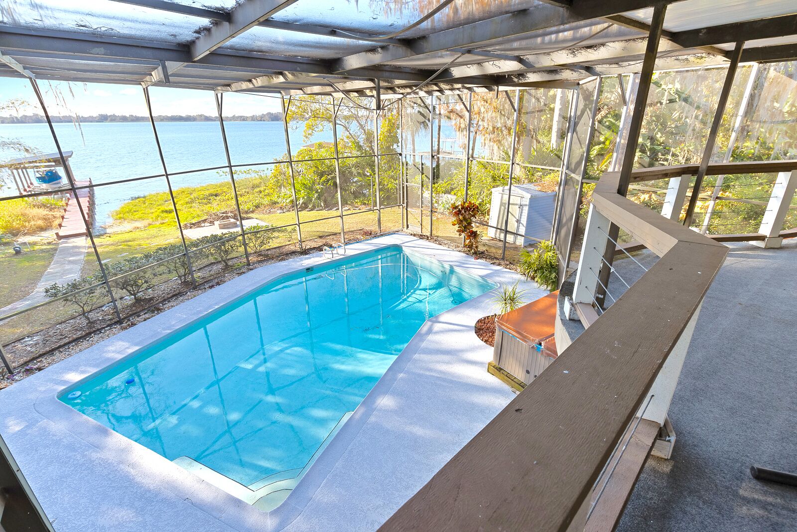 En pool med tak, med utsikt över en sjö och den omgivande naturen.