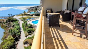 Un balcon avec vue sur une plage et une piscine.