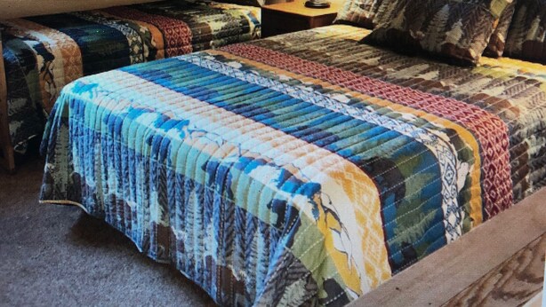 A bedroom with a large bed, a television on the wall, and a window. - Pet friendly, newly updated, 2 bedroom and a loft woodlands unit (Mammoth Lakes)