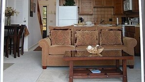 Una sala de estar con un sofá, una mesa de centro y un cuadro en la pared.