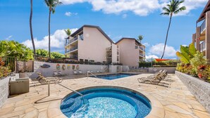A swimming pool with lounge chairs and a building with balconies in the background. - Rare, Spacious Penthouse, Big Ocean and Mountain Views, Great Location,  AC (Maui)