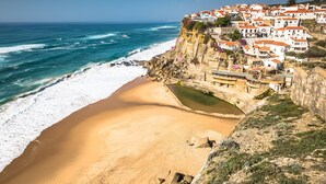 A coastal town with buildings on a cliff overlooking the beach and ocean. - Unique Romantic Beach House by the Atlantic Ocean (Colares)