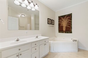 A bathroom with two sinks, a large mirror, a wall-mounted towel rack, and a large bathtub. - River & Marsh Views - Pool, Walk to Downtown Folly, Pet Friendly w/fee - Marshwinds! (Folly Beach)