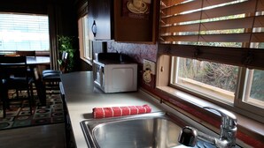 Une cuisine équipée d’un évier en acier inoxydable, d’un grille-pain et d’une serviette rouge posée sur le comptoir.