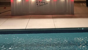 Eine Poolbar mit einem Schild, auf dem 'SHAKEY'S SNACK' steht, und einem weiteren Schild, das 'Es ist 17 Uhr irgendwo' sagt.