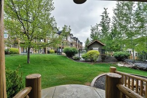 A residential area with a well-maintained lawn, a small wooden cabin, and multi-story buildings in the background. - 4 Bedroom 3 bath easiest access to hot tub (Eden)