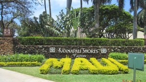 Zona ajardinada con un letrero que dice "Kaanapali Shores" y la palabra "Maui" en amarillo.
