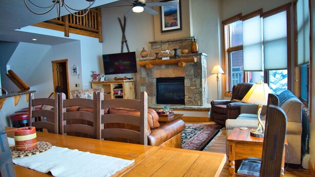 Un salon chaleureux avec une cheminée, des meubles en bois et un téléviseur.