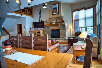 Living room w/ 65” TV, gas fireplace, 2 couches (1 queen bed) & power recliner.