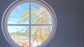 Una ventana con vista a palmeras y un edificio.