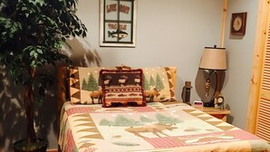 Un dormitorio con una cama de madera, una planta en maceta, un reloj de pared y un cuadro enmarcado.