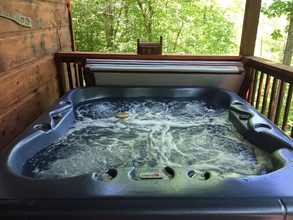 A hot tub on a wooden deck with a view of trees. - Secluded! Private! Come to LAZY BEAR to get away from it all! Large Hot Tub! (Sevierville)